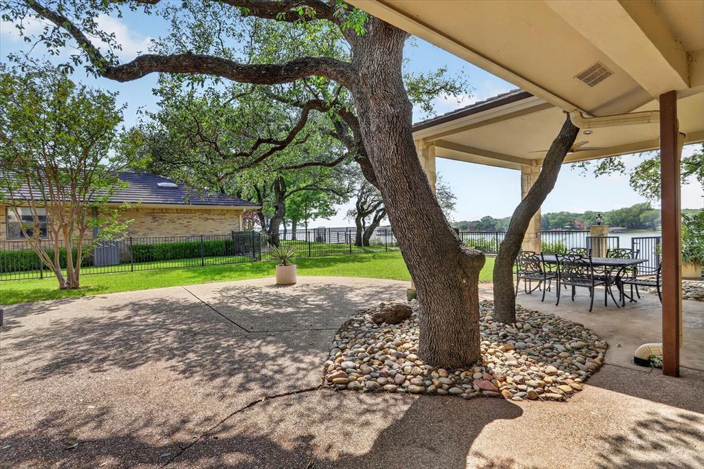 8877 Random Road Fort Worth, TX 76179 - Photo 27 of 40 Expansive outdoor patio with a covered seating area overlooking the water