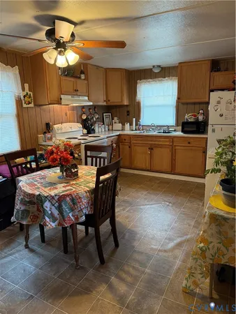 a kitchen with stainless steel appliances granite countertop a sink a stove a dining table and chairs