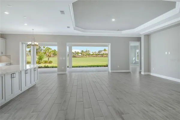 a view of a kitchen with white cabinets wooden floor and stainless steel appliances