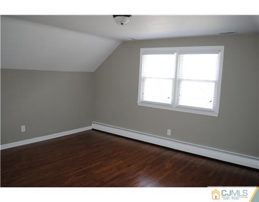 19 Highfield Road Colonia, NJ 07067 - Photo 12 of 17 a view of an empty room with wooden floor and a window