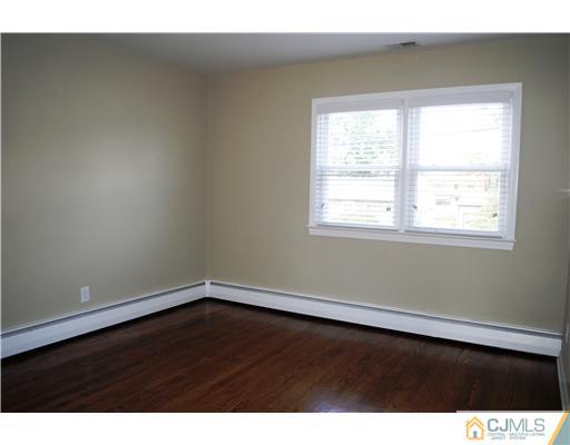 19 Highfield Road Colonia, NJ 07067 - Photo 15 of 17 a view of an empty room with wooden floor and a window