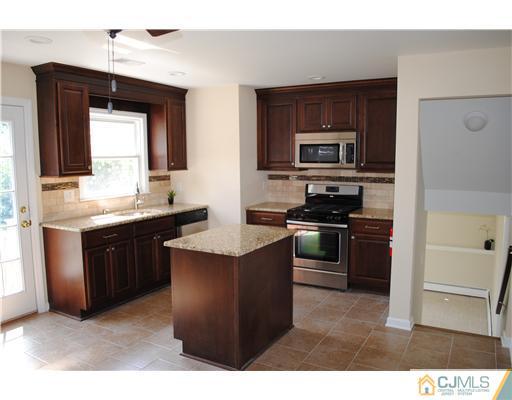 19 Highfield Road Colonia, NJ 07067 - Photo 6 of 17 a kitchen with stainless steel appliances kitchen island granite countertop a stove sink and microwave