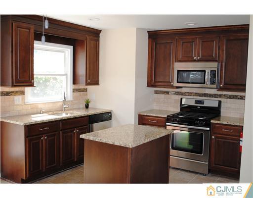 19 Highfield Road Colonia, NJ 07067 - Photo 7 of 17 a kitchen with stainless steel appliances granite countertop a stove microwave and sink