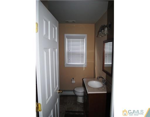 19 Highfield Road Colonia, NJ 07067 - Photo 8 of 17 a bathroom with a sink a toilet and mirror