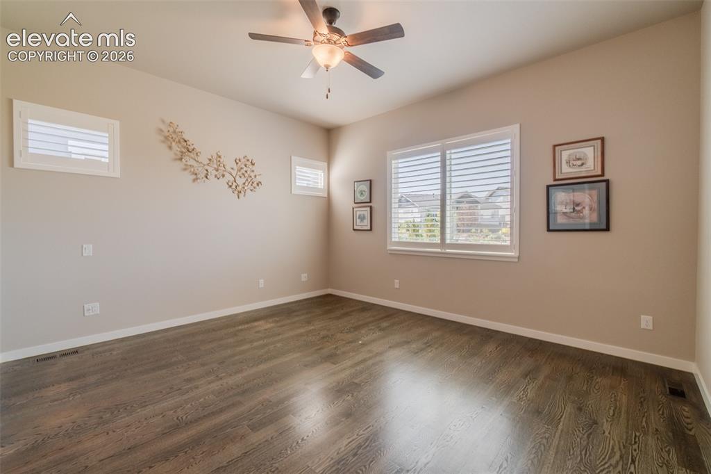 1061 Native Dancer Terrace Colorado Springs, CO 80921 - Photo 30 of 50 Spacious room featuring wood-finish flooring, neutral-toned walls, and a ceiling fan with integrated lighting