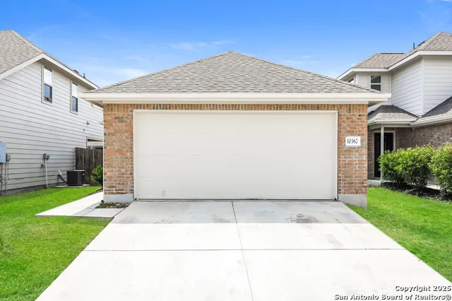 a view of a white house next to a yard with big trees