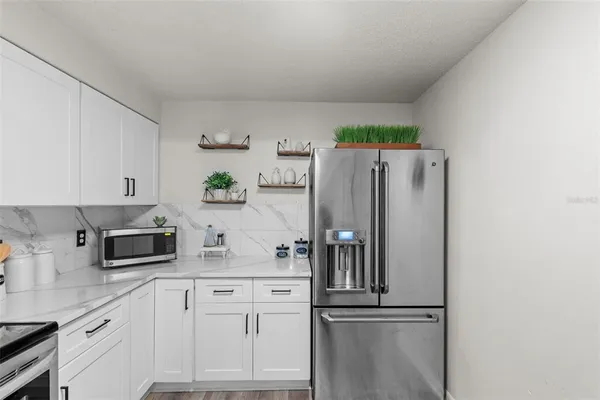 a kitchen with stainless steel appliances white cabinets and a refrigerator