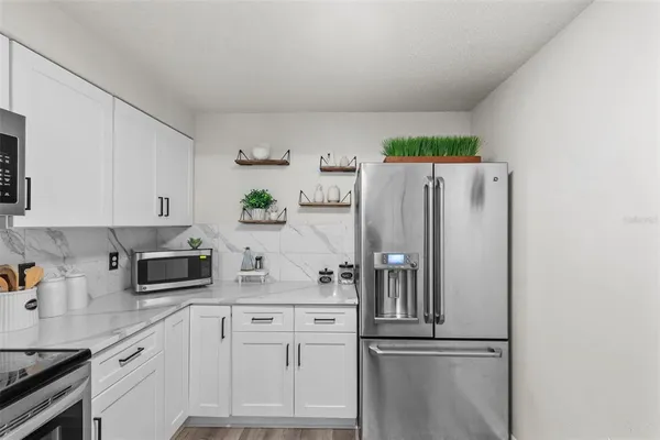 a kitchen with stainless steel appliances white cabinets and a refrigerator