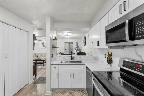 a kitchen with stainless steel appliances a stove microwave and sink