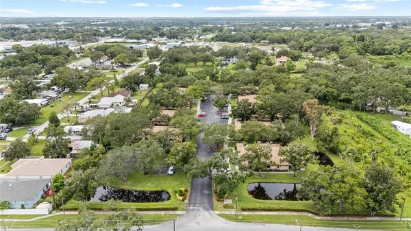an aerial view of residential houses with outdoor space and trees