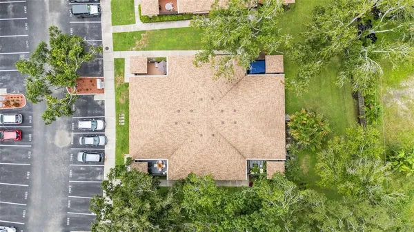 an aerial view of a house with outdoor space and trees in the back