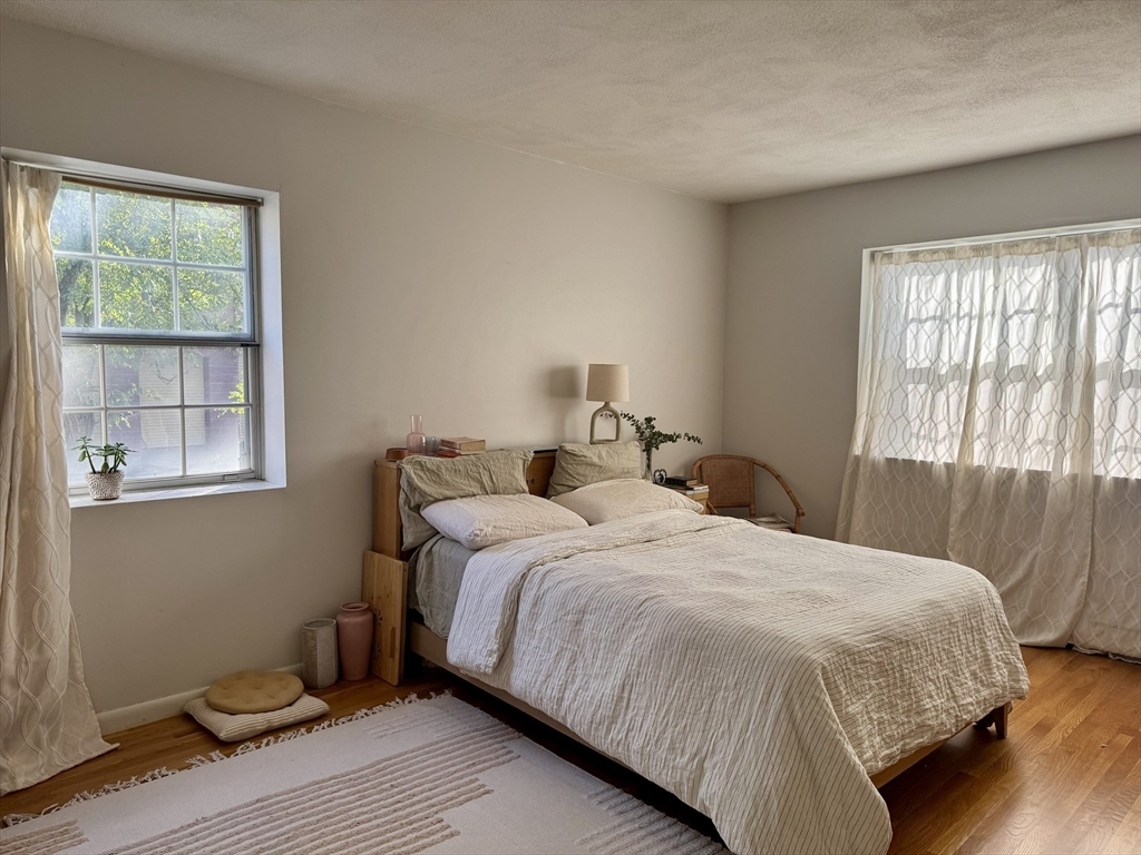 8 Robinwood Avenue, Unit 6 Boston, MA 02130 - Photo 3 of 5 a bedroom with a bed and wooden floor