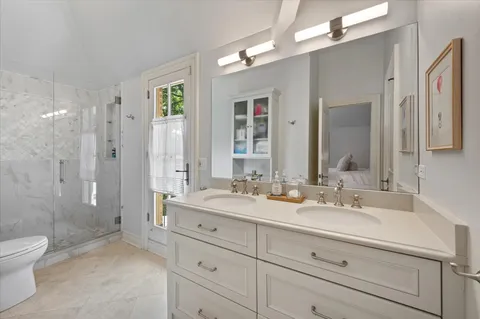 a bathroom with a granite countertop sink a toilet and shower