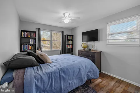 a bedroom with a bed and a flat tv screen on dresser