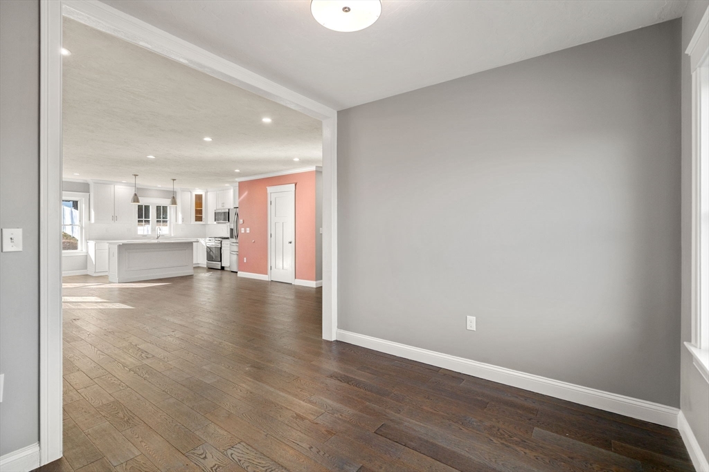 93 Providence Street, Unit B Mendon, MA 01756 - Photo 18 of 37 a view of a kitchen and an empty room with wooden floor