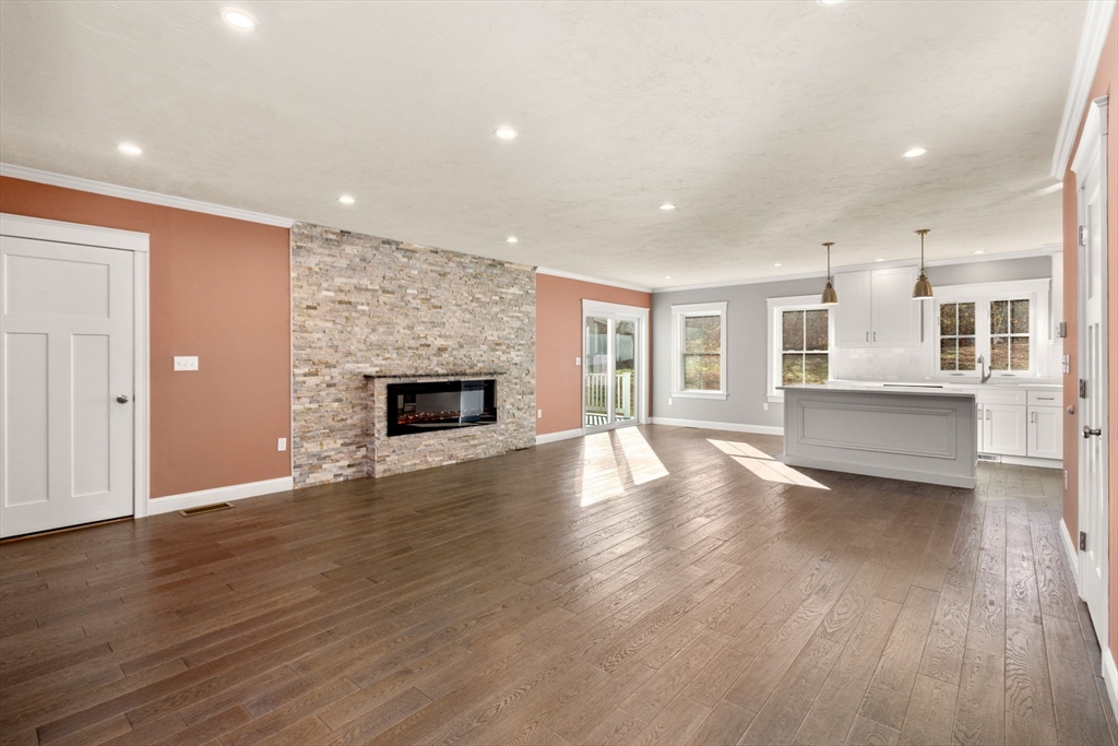 93 Providence Street, Unit B Mendon, MA 01756 - Photo 9 of 37 an empty room with wooden floor and fireplace