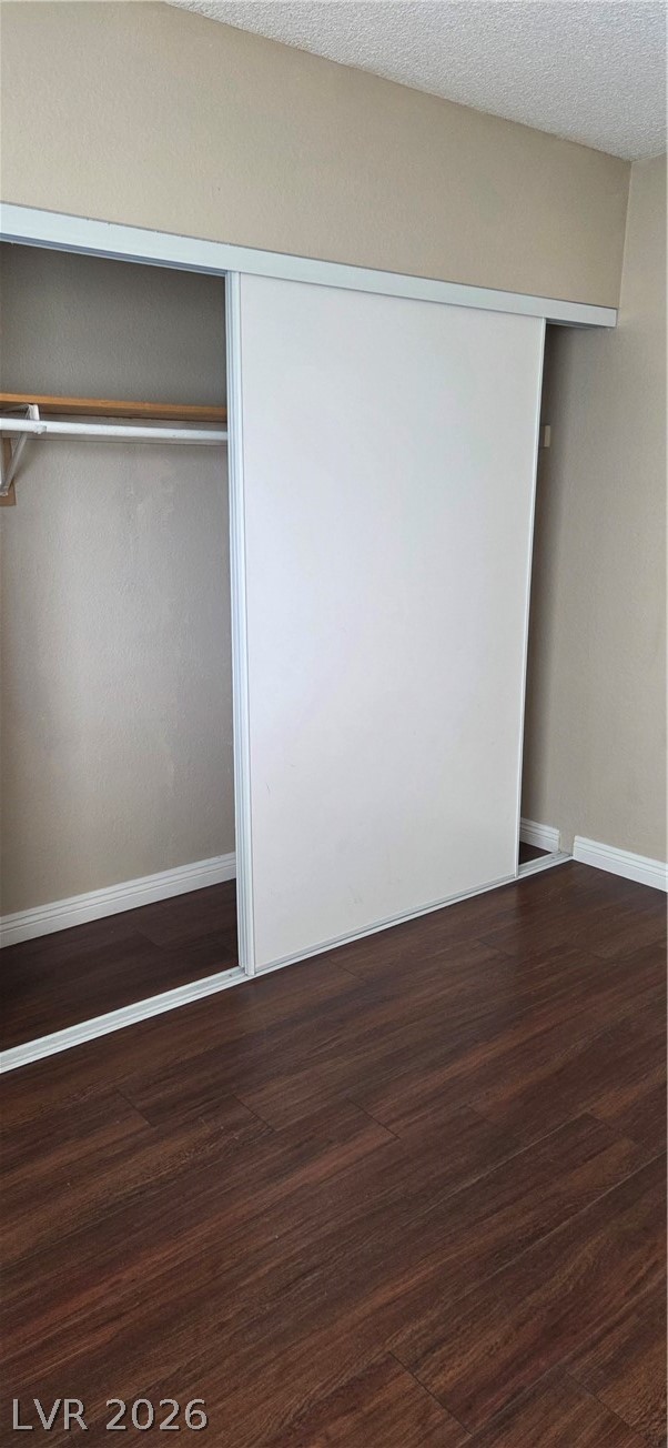 571 Roxella Lane, Unit C Las Vegas, NV 89110 - Photo 5 of 14 This bedroom features ample storage with sliding closet doors and rich wood flooring.