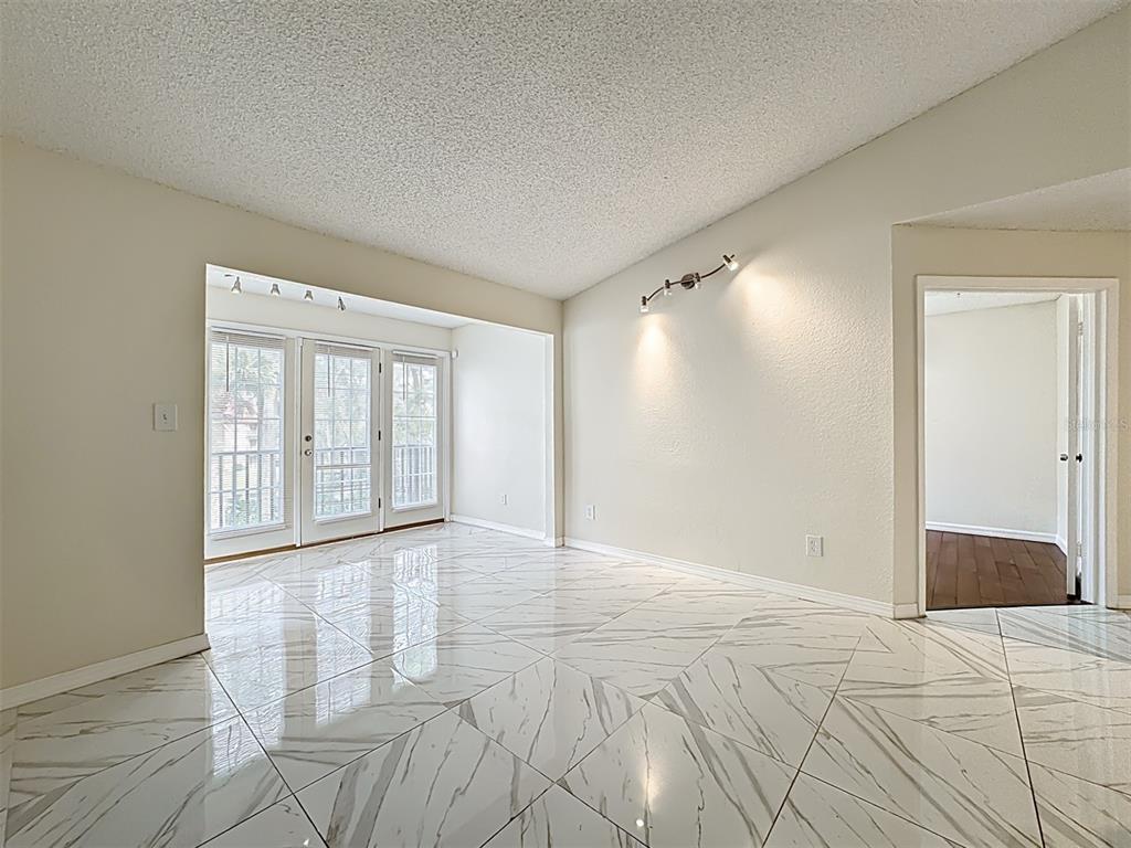 232 Afton Square, Unit 201 Altamonte Springs, FL 32714 - Photo 14 of 54 a view of an empty room with wooden floor and a window