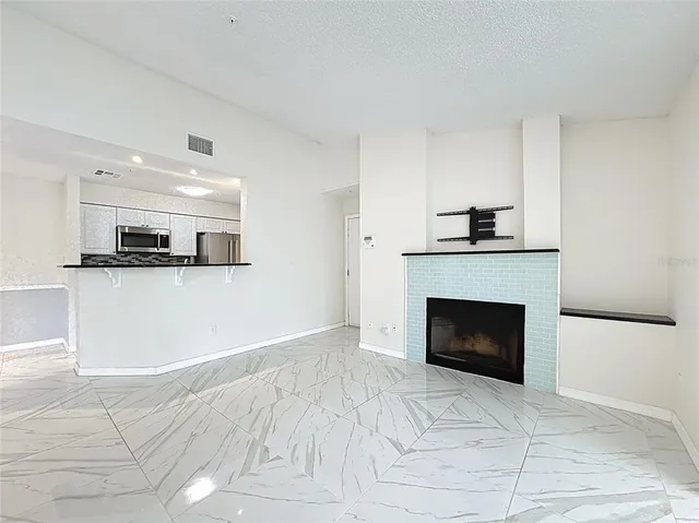 a kitchen with stainless steel appliances kitchen island granite countertop a refrigerator and a stove top oven