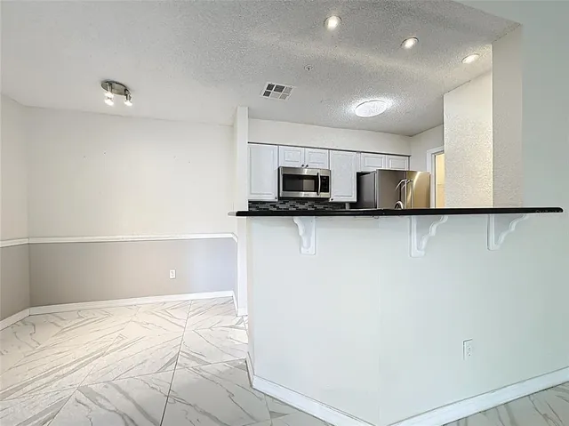 a kitchen with stainless steel appliances a refrigerator and a stove top oven