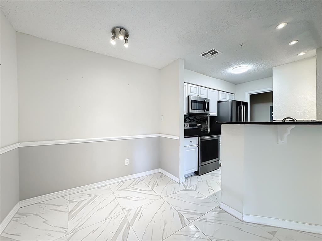 232 Afton Square, Unit 201 Altamonte Springs, FL 32714 - Photo 22 of 54 a kitchen with stainless steel appliances a refrigerator and a stove top oven