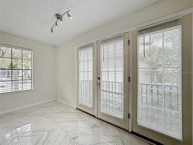a view of a livingroom with a white wall & cabinets
