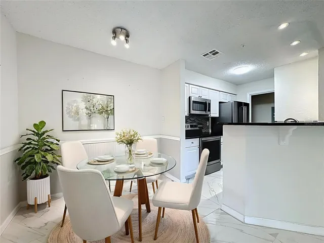 a view of a dining room with furniture and a potted plant