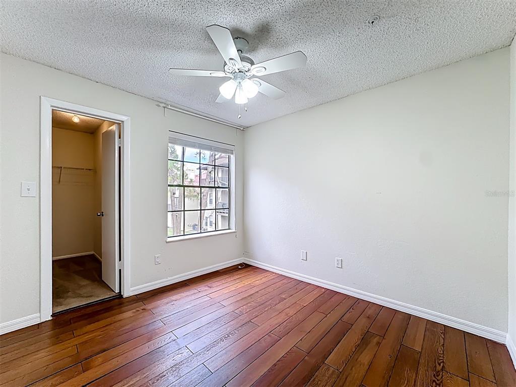 232 Afton Square, Unit 201 Altamonte Springs, FL 32714 - Photo 33 of 54 an empty room with wooden floor fan and windows