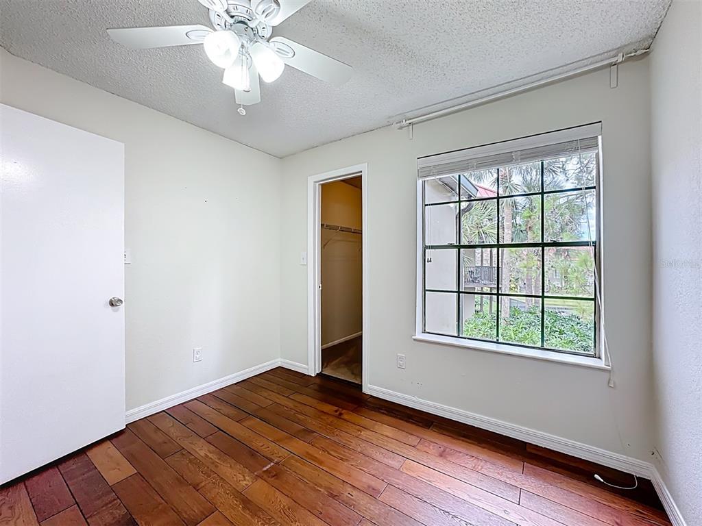 232 Afton Square, Unit 201 Altamonte Springs, FL 32714 - Photo 34 of 54 an empty room with wooden floor chandelier fan and windows