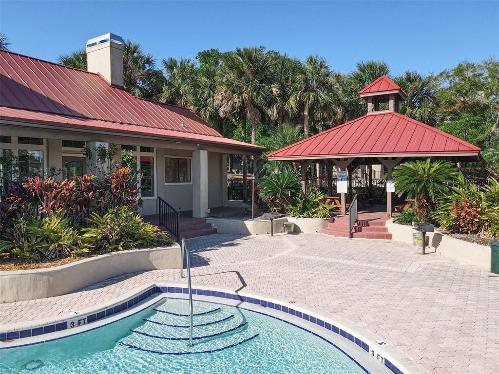 232 Afton Square, Unit 201 Altamonte Springs, FL 32714 - Photo 45 of 54 a patio with a table and chairs under an umbrella