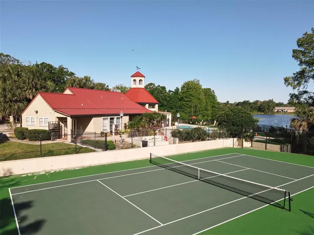 a view of pool with lawn chairs and large trees
