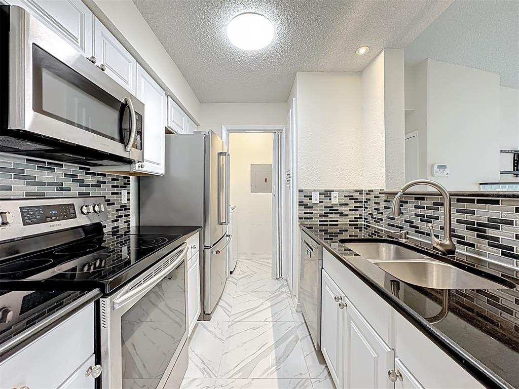 232 Afton Square, Unit 201 Altamonte Springs, FL 32714 - Photo 5 of 54 a kitchen with granite countertop a sink stove and refrigerator