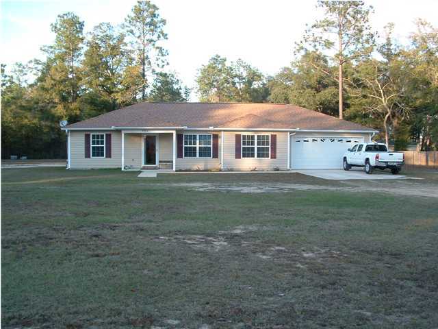 893 Lighthouse Church Road Holt, FL 32564 - Photo 4 of 24 a front view of a house with a garden