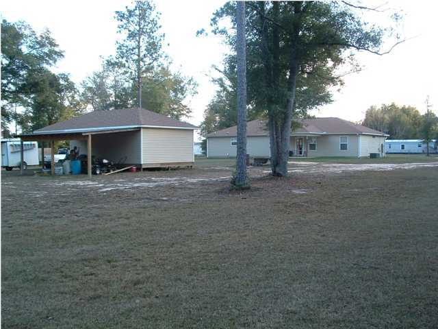 893 Lighthouse Church Road Holt, FL 32564 - Photo 9 of 24 a view of a house with a tree in front of it