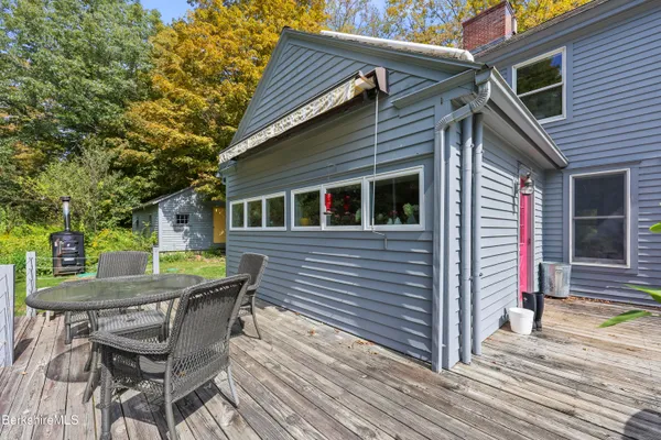 a backyard of a house with table and chairs and potted plants