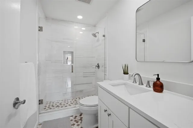 a bathroom with a sink a toilet and shower