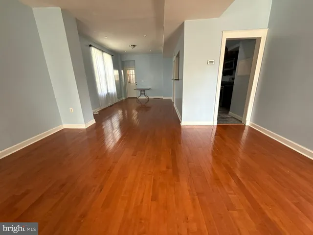 a living room with hard wood floor and a flat screen tv