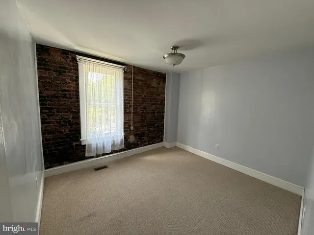 an empty room with a ceiling fan and a window