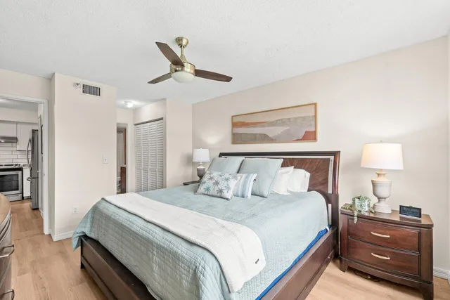 a bedroom with a bed and a lamp on a dresser