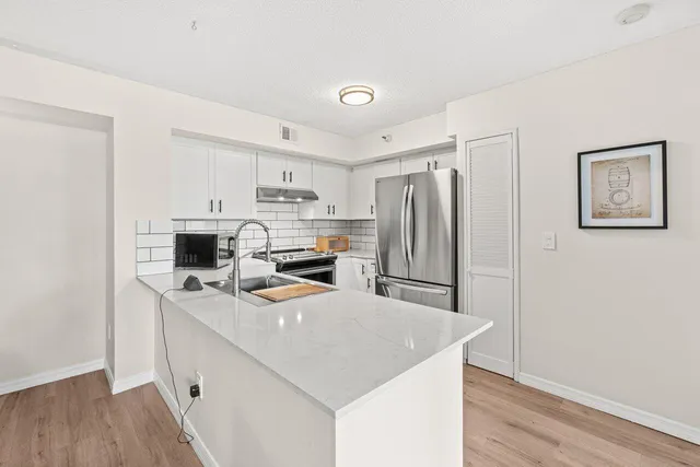 a kitchen with stainless steel appliances a refrigerator sink and microwave
