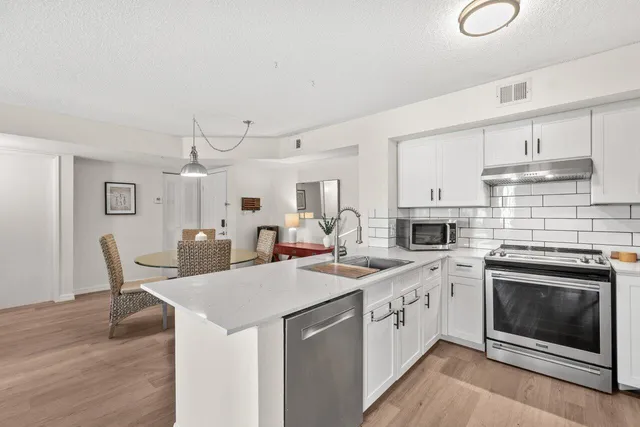 a kitchen with a stove sink and cabinets