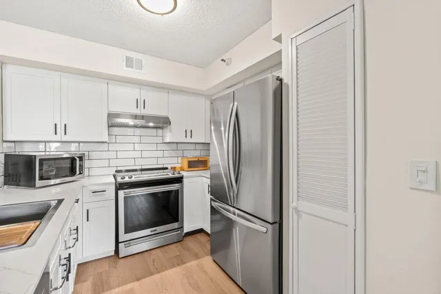 a kitchen with stainless steel appliances a refrigerator sink and cabinets