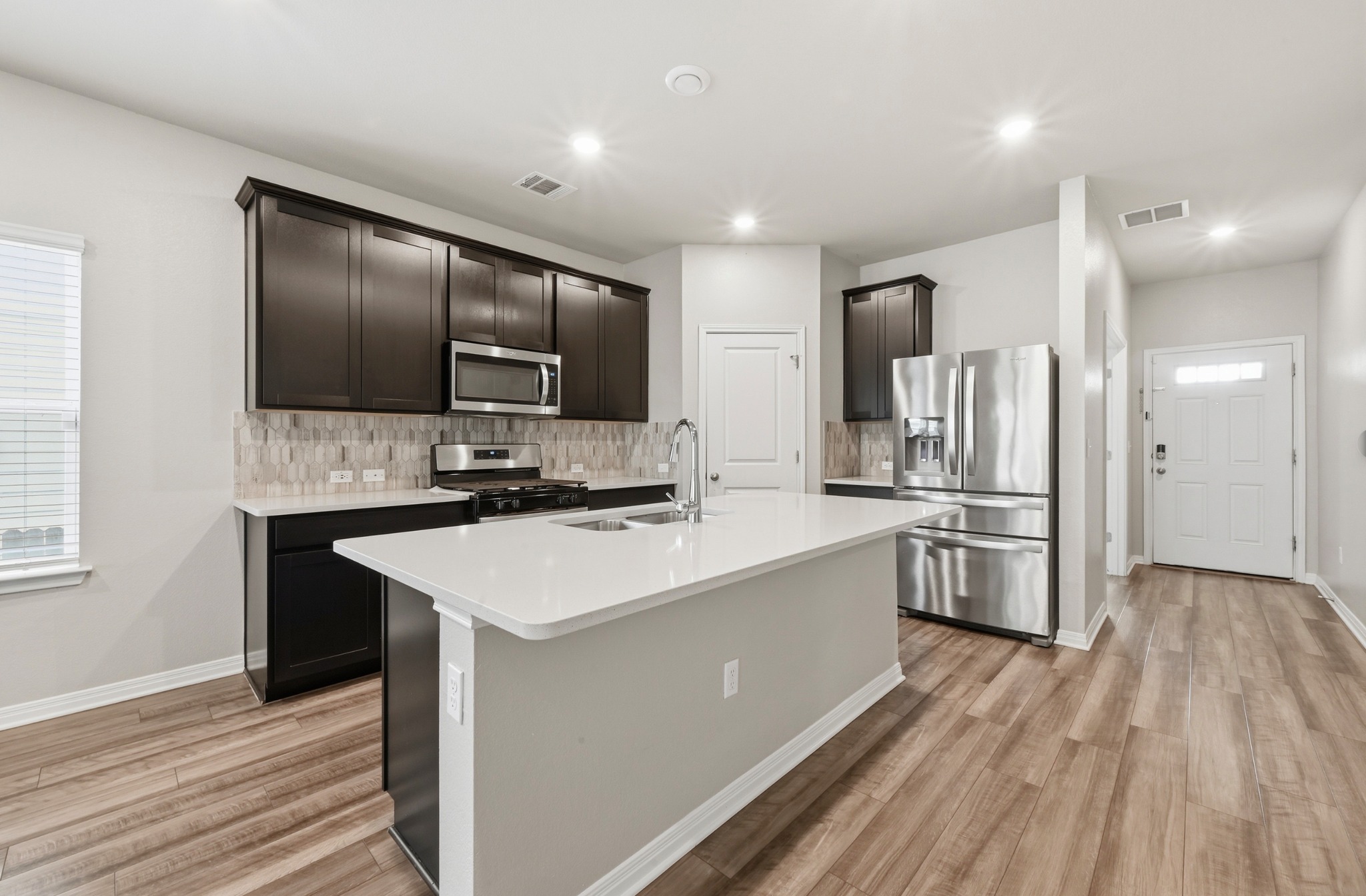 12606 Dairywork Road Buda, TX 78610 - Photo 8 of 32 Between the stainless appliances and the quartz countertops, this kitchen is ready for everything from quick snacks to holiday cooking