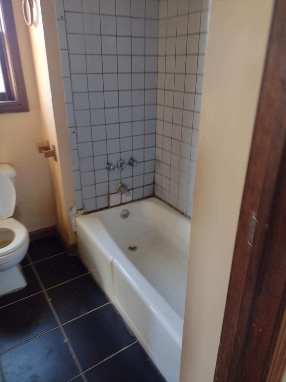 54 Bay Street Fall River, MA 02721 - Photo 3 of 16 a bathroom with a bathtub and toilet
