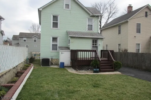 a view of a house with backyard and wooden fence