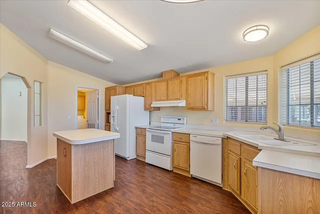 a spacious bedroom with a bed and wooden floor