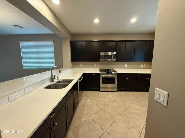 a kitchen with stainless steel appliances a refrigerator and a stove top oven