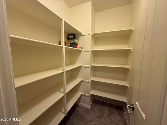 an empty room with windows and chandelier fan