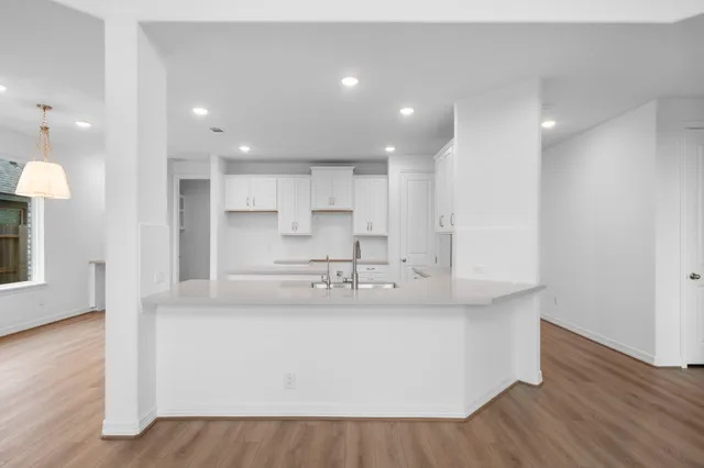 a large kitchen with stainless steel appliances granite countertop a white stove top oven and white cabinets