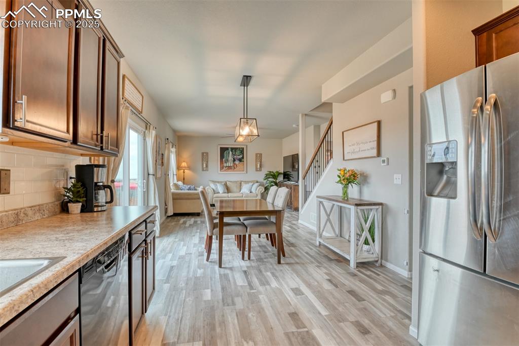 Undisclosed Address Peyton, CO 80831 - Photo 17 of 50 a kitchen with stainless steel appliances granite countertop a refrigerator a stove top oven a sink dishwasher and dining table with wooden floor